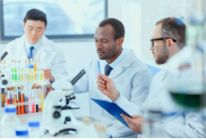 three laboratory workers at a bench