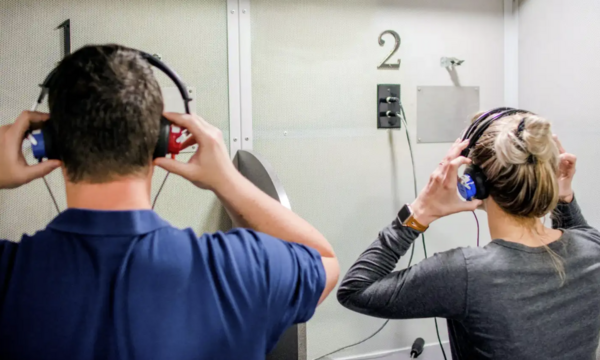two people putting on headphones